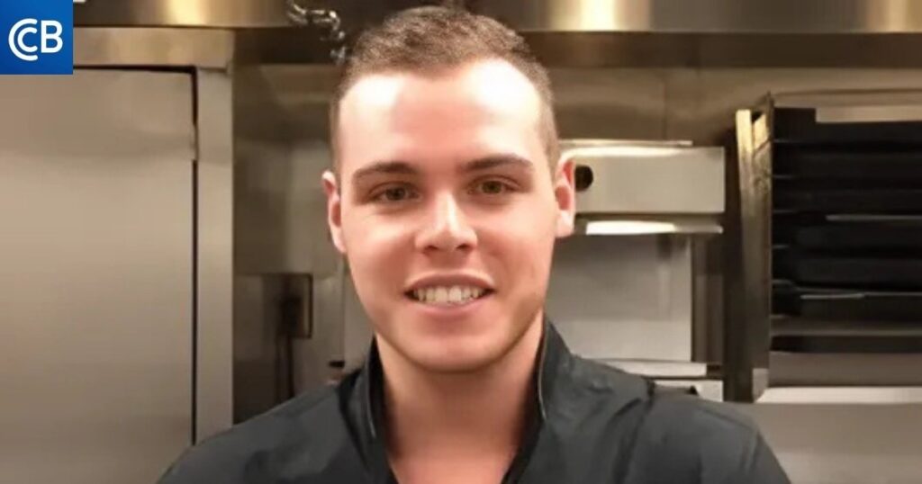 a person in a black shirt standing in a kitchen